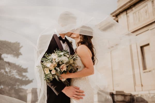 Newlyweds embracing with a bouquet