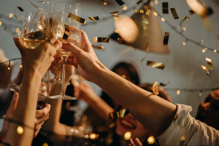 Friends raising glasses in a warm candlelit toast